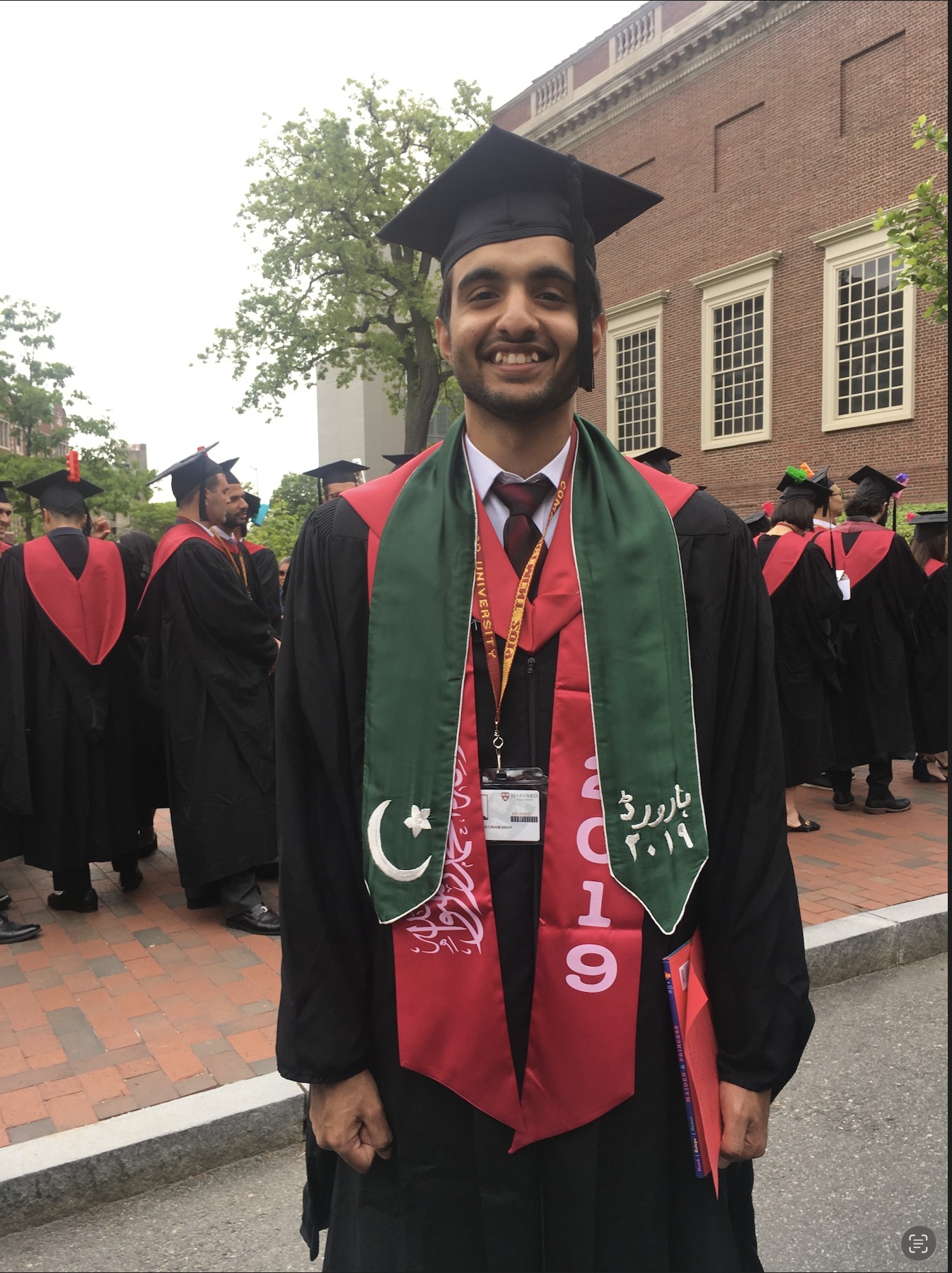 Umair at Harvard's 2019 commencement, wearing a green stole embroidered in Urdu